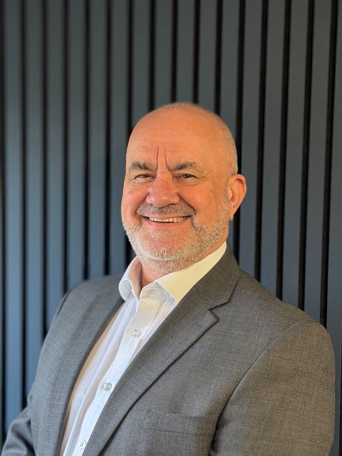 Smiling bald man in grey suit portrait