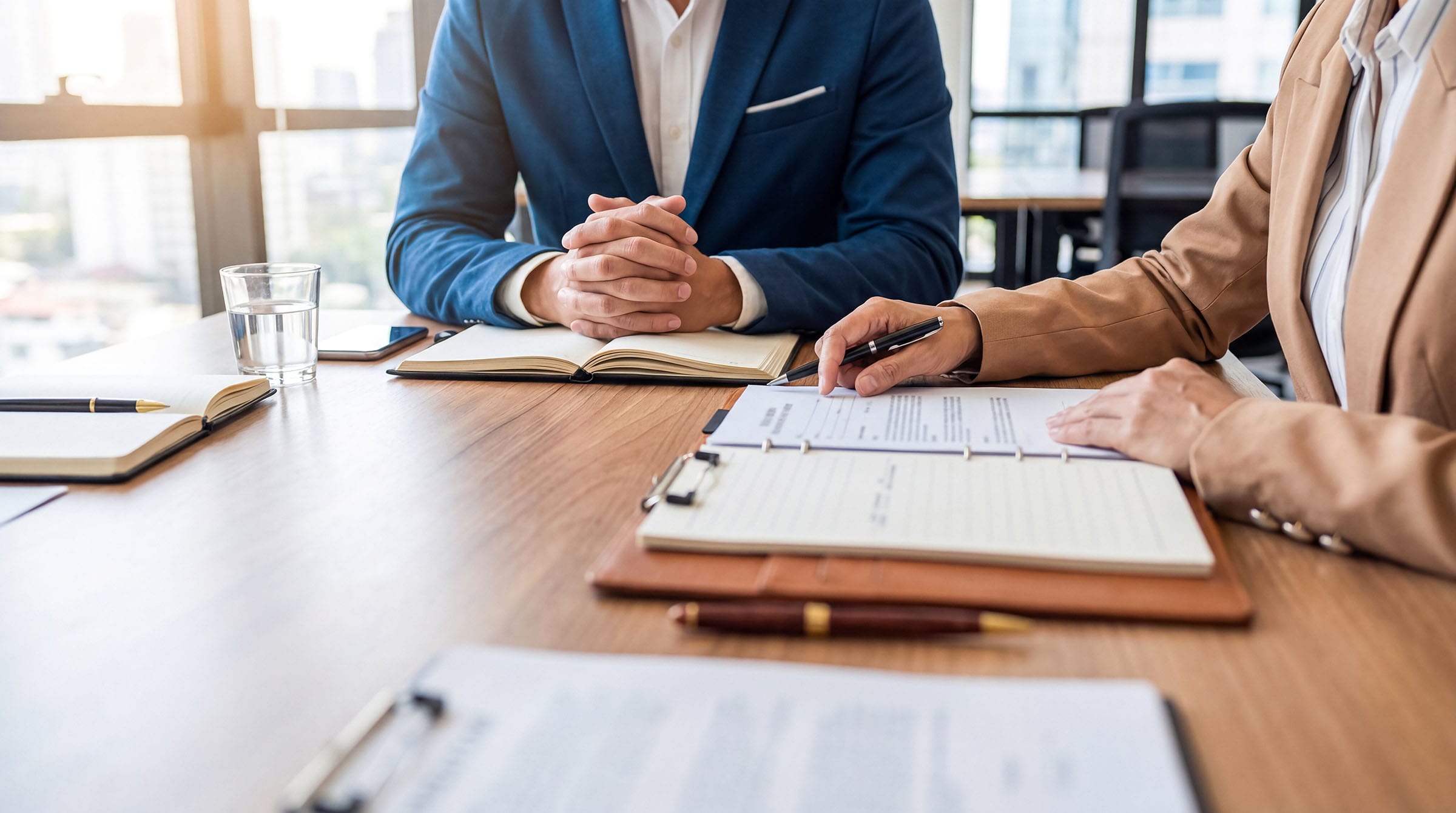 Business meeting reviewing documents at office desk