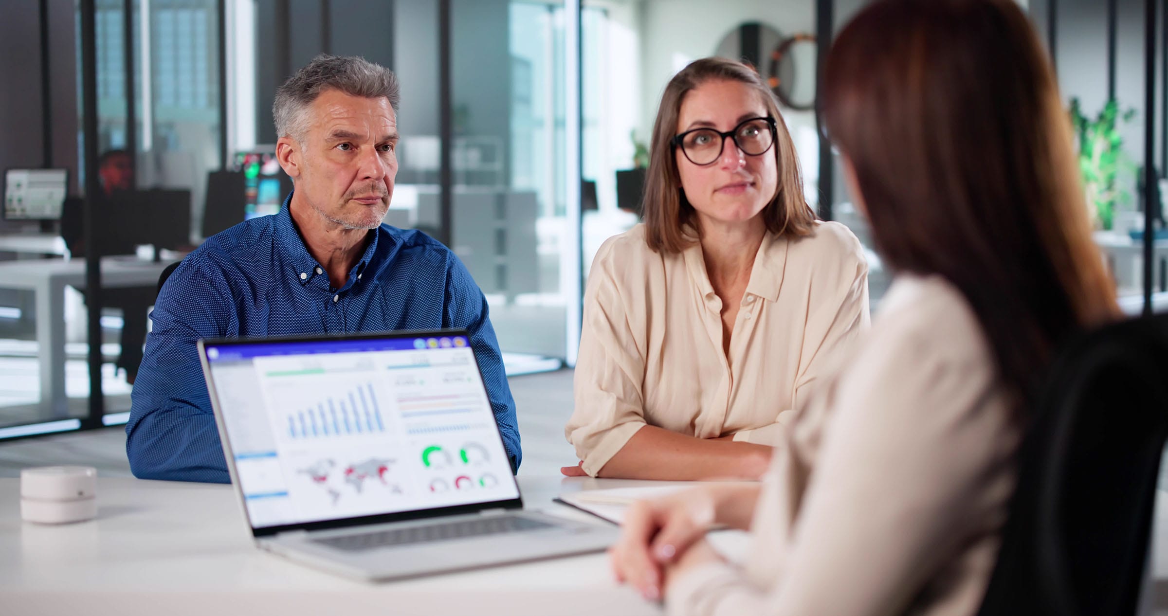 Business meeting reviewing analytics on laptop
