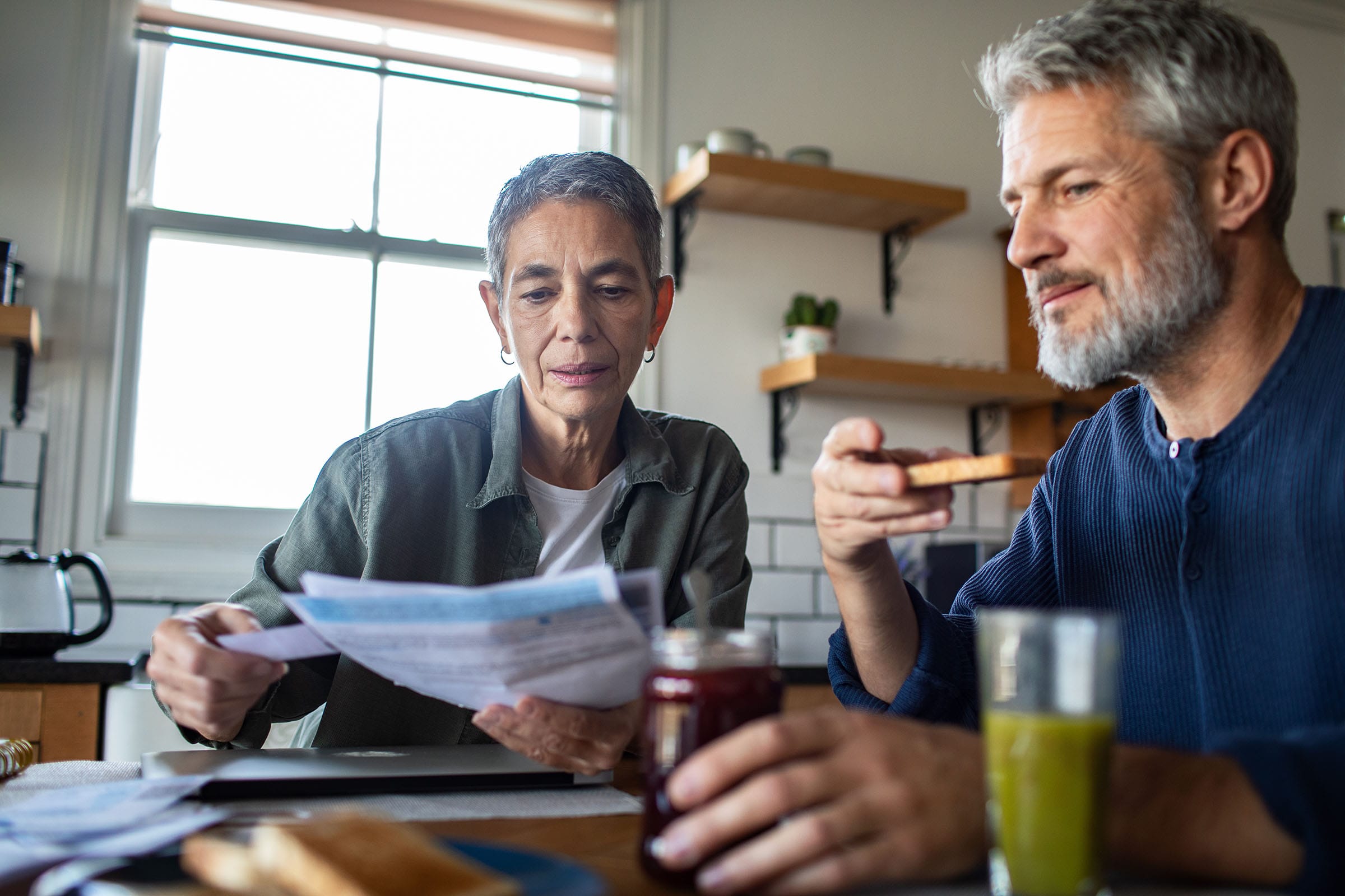 Couple reviewing paperwork at kitchen breakfast table