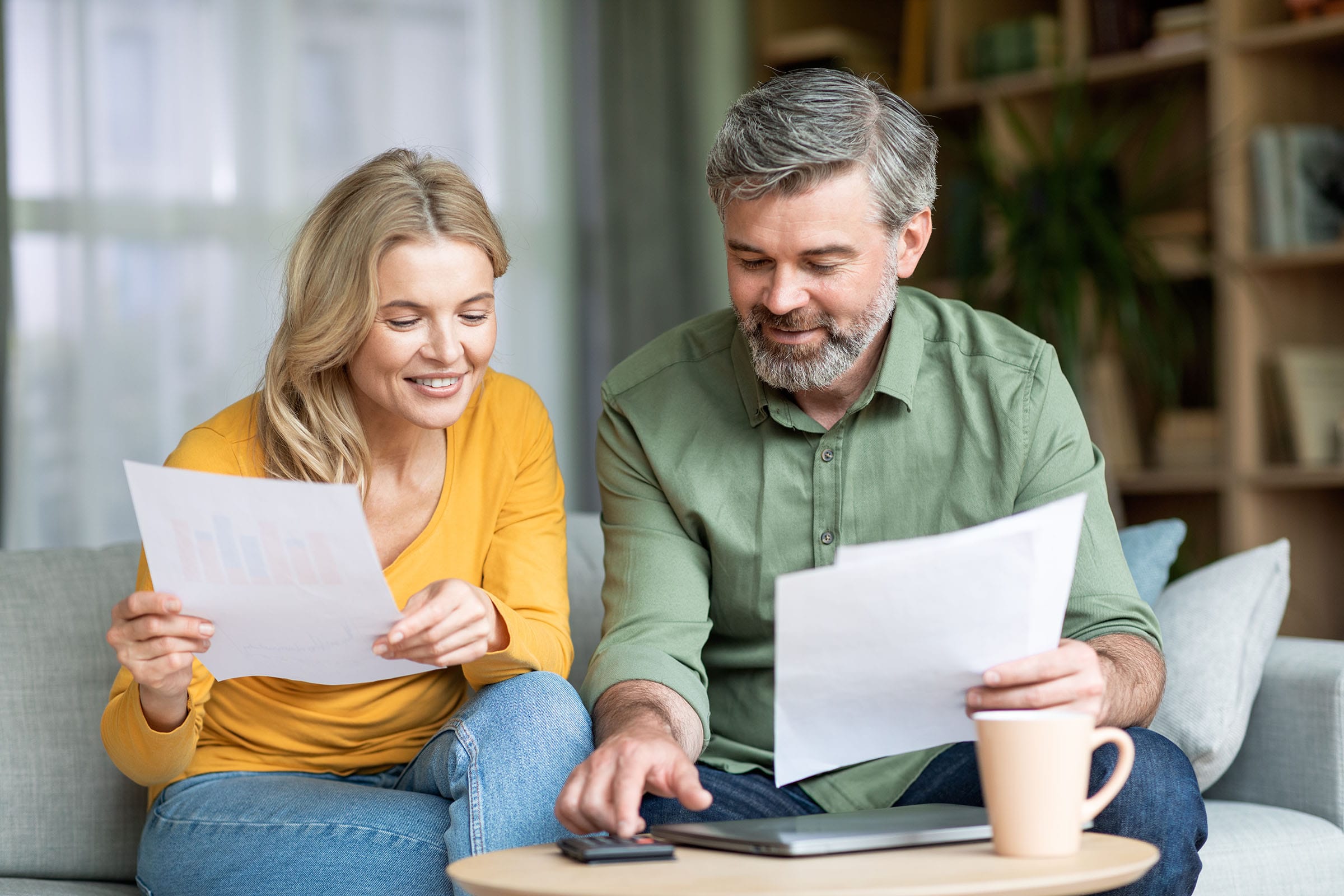 Couple reviewing financial documents at home together