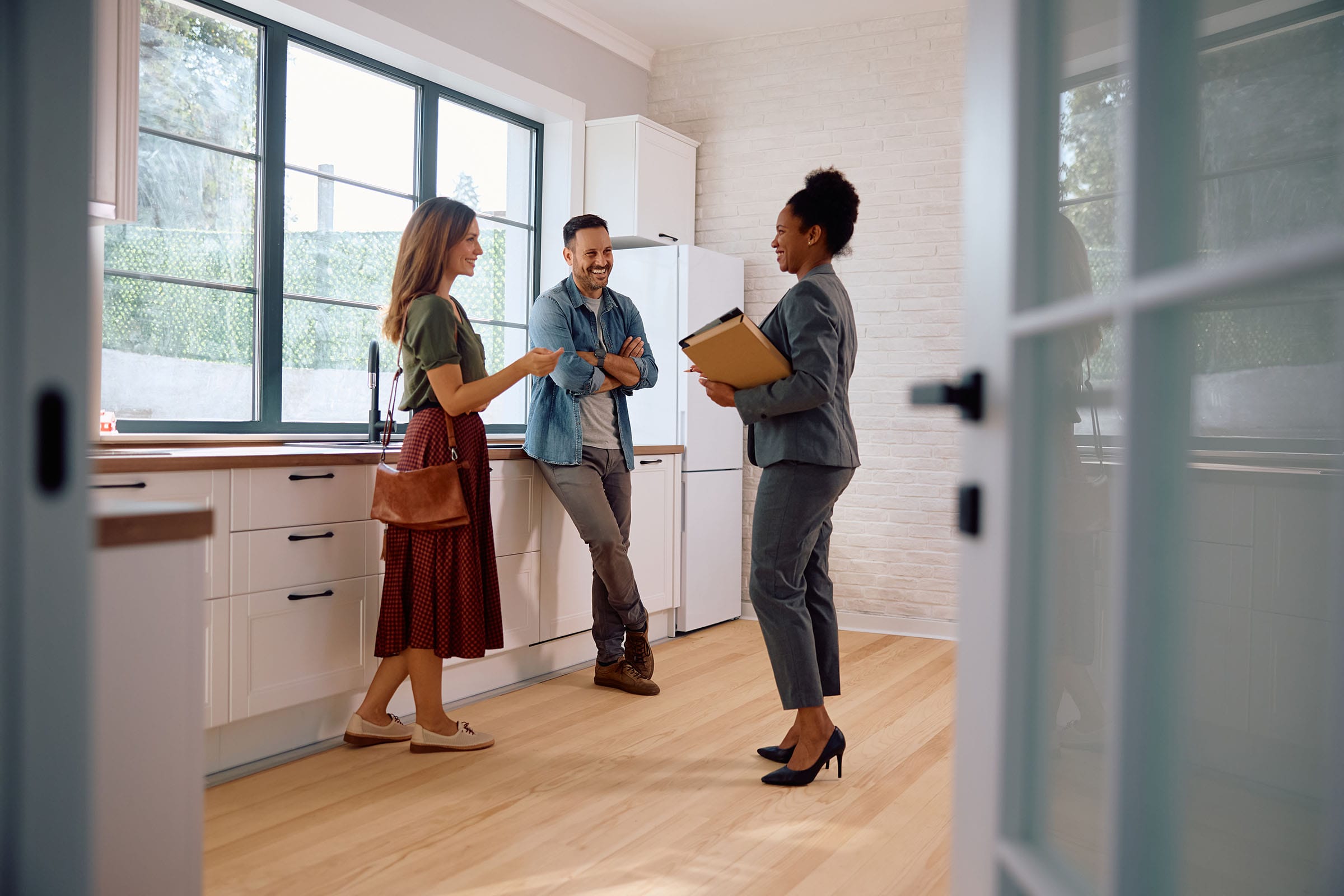 Estate agent showing modern kitchen to couple